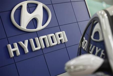 The Hyundai logo is seen next to the company's Sonata sedan at a dealership in Seoul